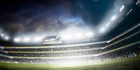 Professional soccer stadium field view with lights, fans and flags
