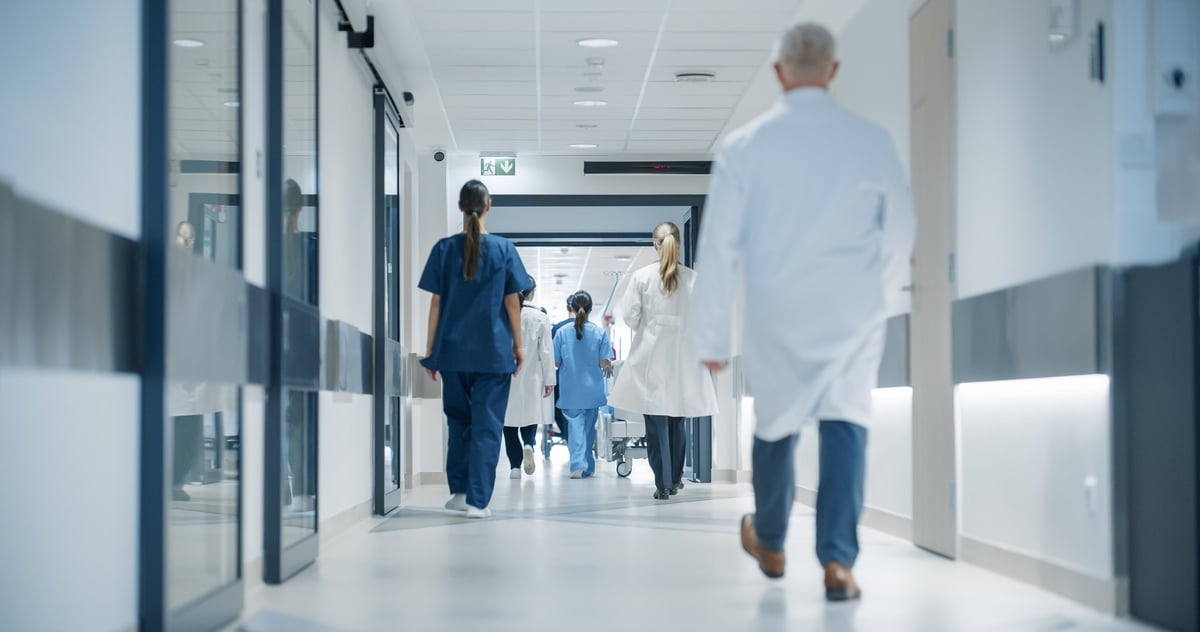 Hospital Hallway with Doctors, Nurses and Specialists - physicians and surgeons walking together in a modern medical corridor