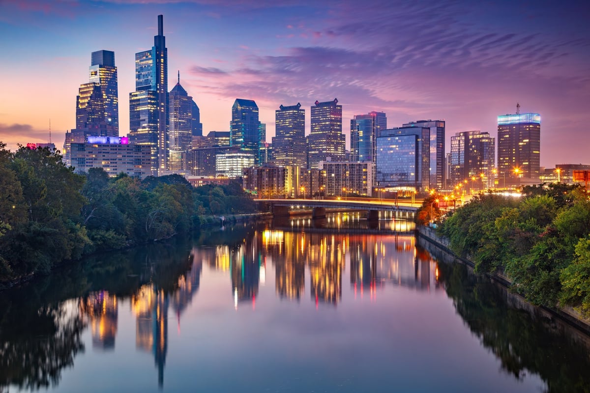 Modern city skyline at twilight with skyscrapers reflecting in calm waters, representing premium urban living