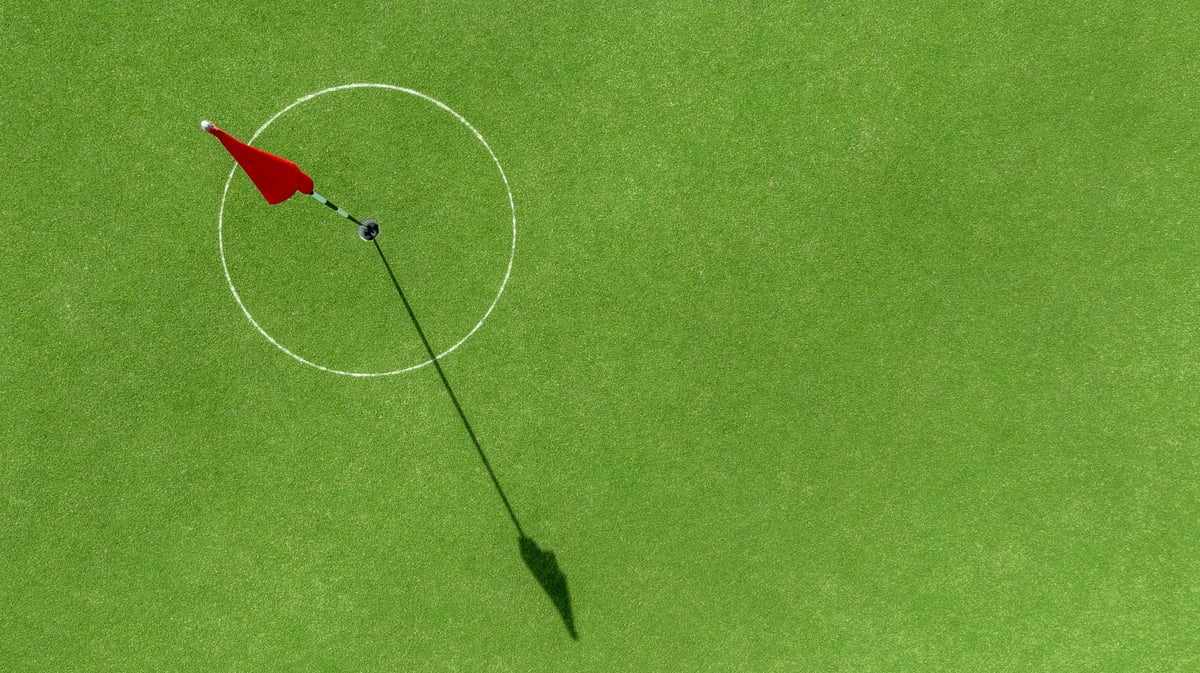 Aerial top view putting green with flag at golf course