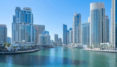Skyline of downtown Chicago with modern high-rise buildings reflected in calm turquoise water along the Chicago River