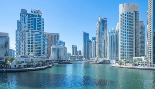 Modern Dubai Marina skyline with skyscrapers reflecting in calm blue waters