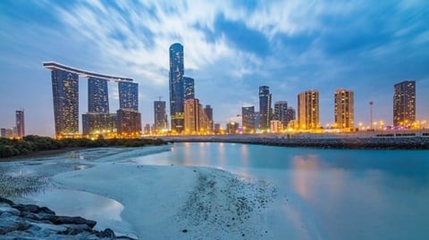 Chicago skyline at dusk with illuminated skyscrapers reflected in Lake Michigan waters during blue hour